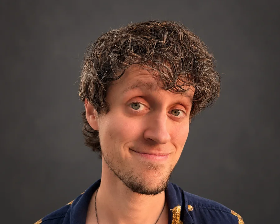 Caleb Vetter in a leopard-print shirt, smiling against a charcoal studio backdrop.