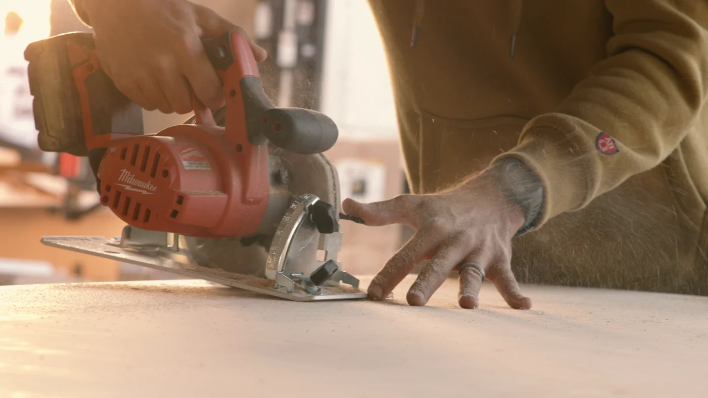 A circular saw cuts a sheet of plywood in Gutted season two.