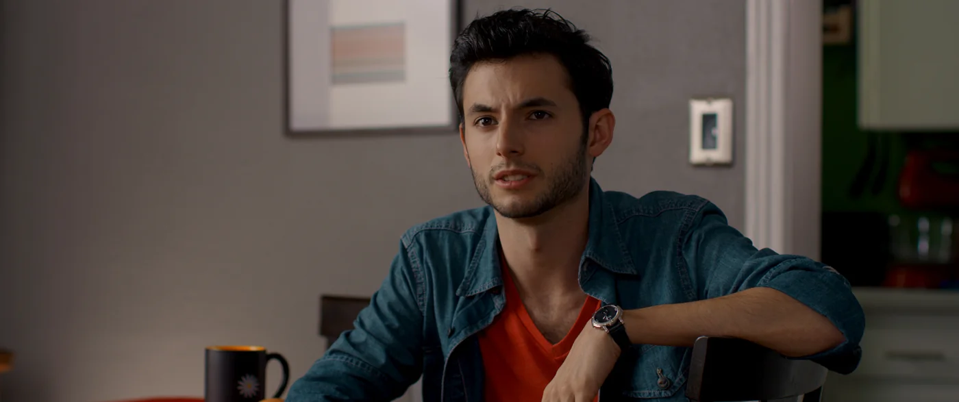 A man in a denim shirt sits at a table with a coffee mug in The Matchbreaker.